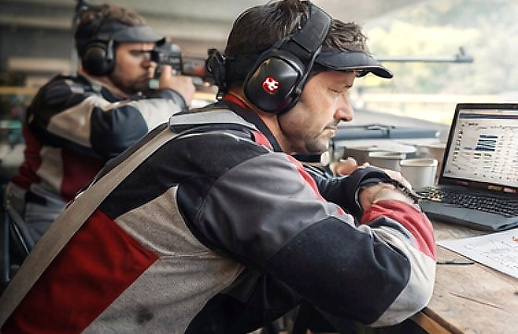 Schütze mit Laptop und Resultatübersicht im Schützenhaus